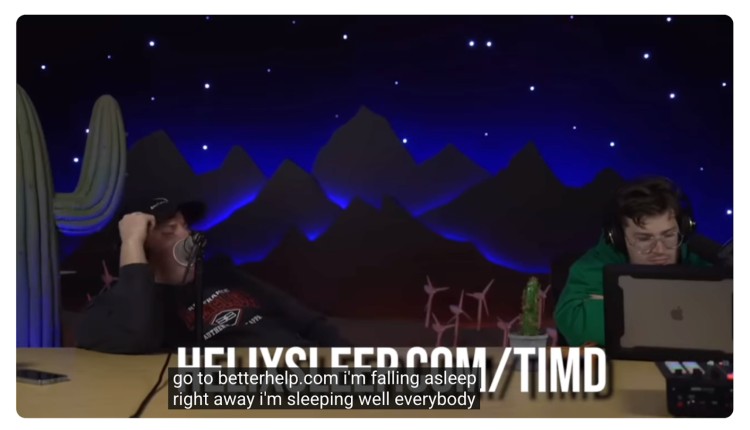 Podcast hosts recording an episode with a visible host-read ad and caption promoting BetterHelp, illustrating a host-read style of podcast advertising.