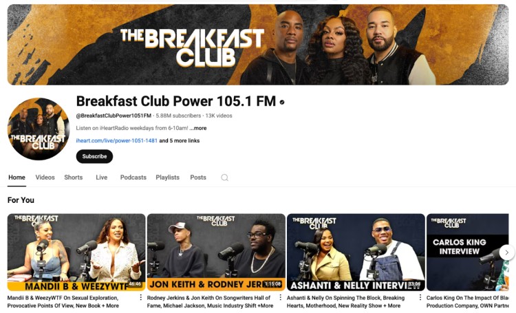 Screenshot of The Breakfast Club radio show’s official YouTube channel, featuring hosts Charlamagne Tha God, DJ Envy, and Angela Yee, with clips from celebrity interviews.