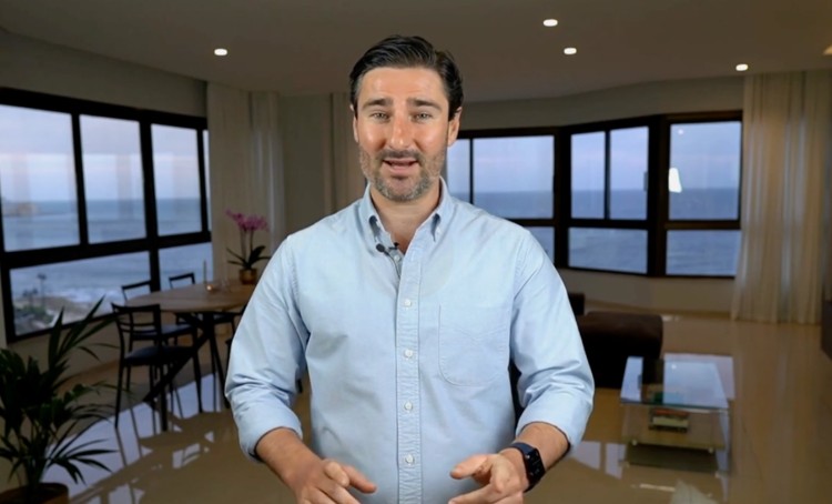 Liam Austin presenting in a bright room using a lavalier microphone for clear audio during video recording