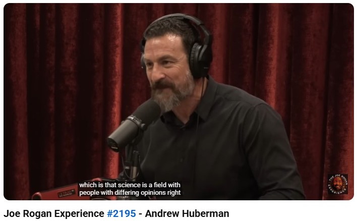 Andrew Huberman speaking on the Joe Rogan Experience podcast, discussing science, neuroscience, and differing opinions in research.