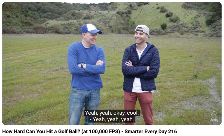 Two youtuber creators discussing a high-speed golf ball experiment outdoors