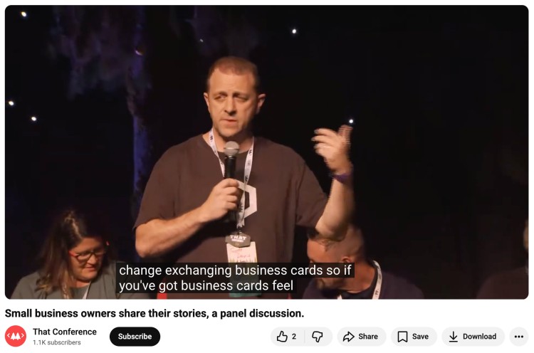 Speaker holding a microphone during an interesting discussion at a small business panel, sharing real experiences and insights on stage.