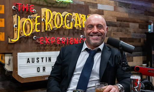 Joe Rogan smiling in his studio, widely regarded as one of the most engaging podcast hosts in long-form interviews