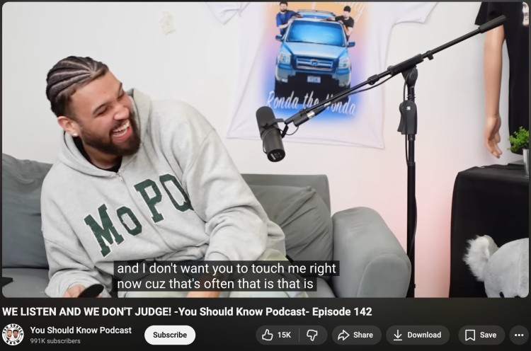 Podcast host laughing during a lighthearted banter-filled conversation in a casual studio recording.