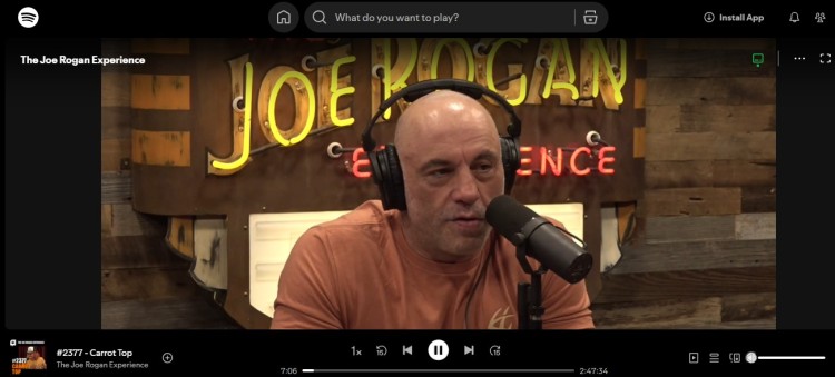 Joe Rogan speaking into a microphone in a professional video podcast setup