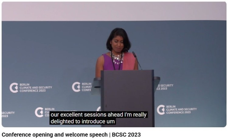 Conference host standing at a podium during an event introduction session