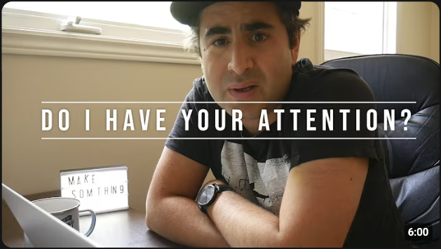 Speaker looking directly at the camera with the words “Do I Have Your Attention?” to illustrate full attention